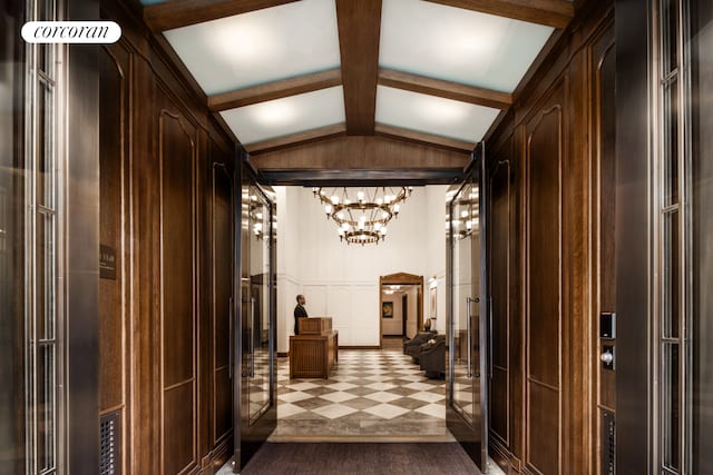 hall with vaulted ceiling with beams and an inviting chandelier