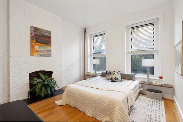 bedroom featuring a fireplace and light wood-type flooring