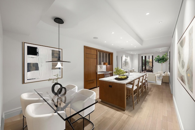 kitchen with decorative light fixtures, a kitchen island, and light hardwood / wood-style floors