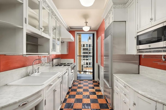 kitchen with sink, built in appliances, crown molding, extractor fan, and white cabinets