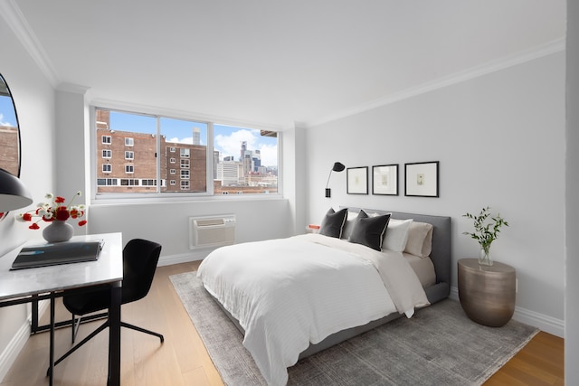 bedroom featuring a wall mounted air conditioner, wood-type flooring, and crown molding