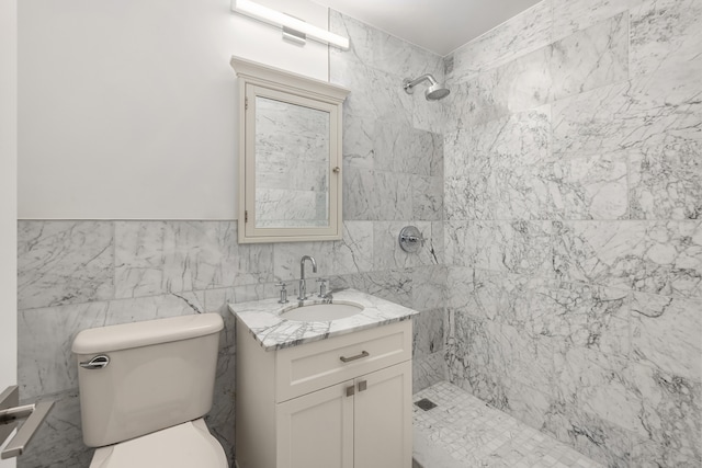 bathroom featuring toilet, vanity, tile walls, and tiled shower