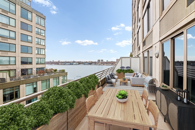 balcony with outdoor lounge area, a grill, and a water view