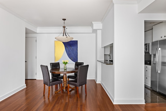 dining room featuring dark hardwood / wood-style flooring and crown molding