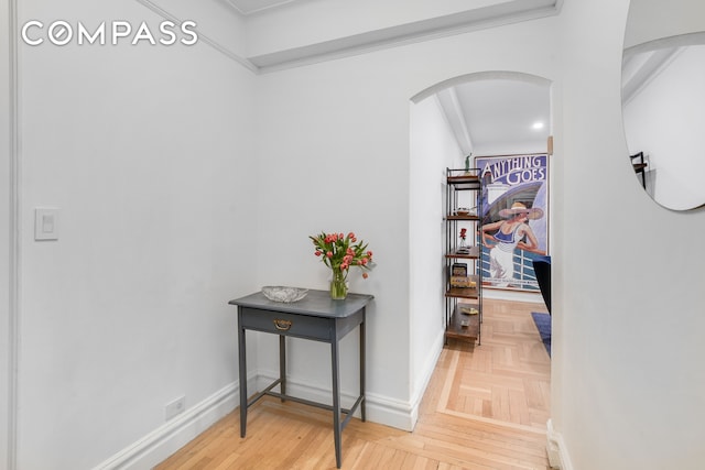 hallway with crown molding and parquet flooring