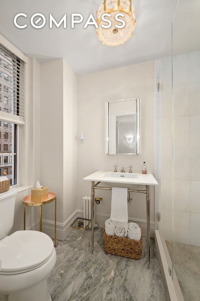 bathroom with sink, an enclosed shower, and toilet