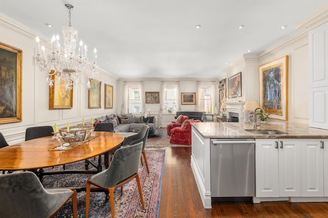 dining room featuring dark hardwood / wood-style flooring, an inviting chandelier, ornamental molding, and sink