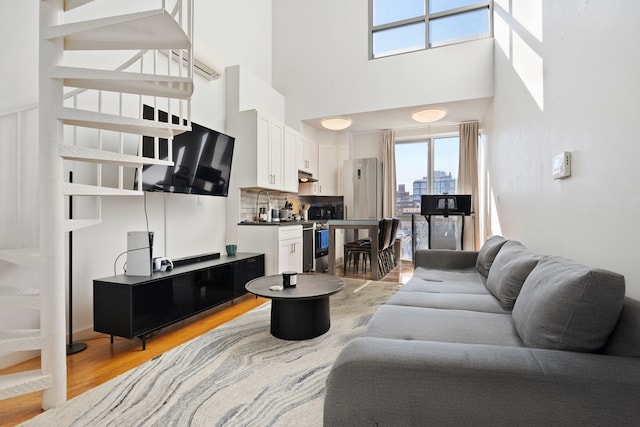 living room featuring a high ceiling and light wood-type flooring