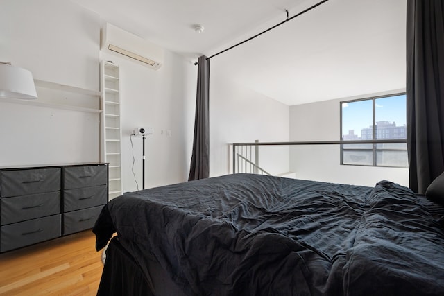 bedroom featuring hardwood / wood-style floors and a wall unit AC