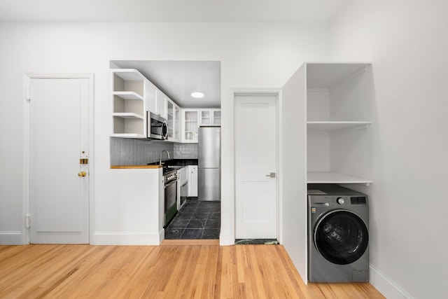 laundry room with washer / dryer, sink, and wood-type flooring