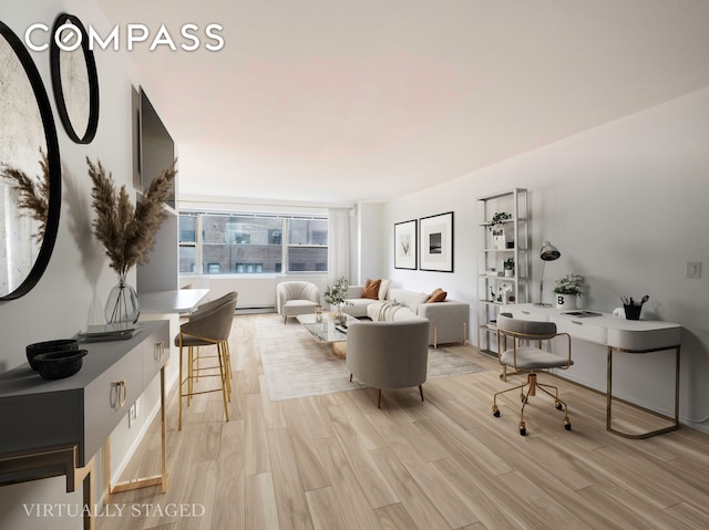 living room with a baseboard heating unit and light hardwood / wood-style flooring