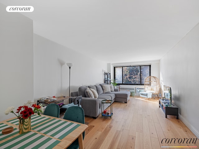 living room featuring floor to ceiling windows, radiator heating unit, and light wood-type flooring