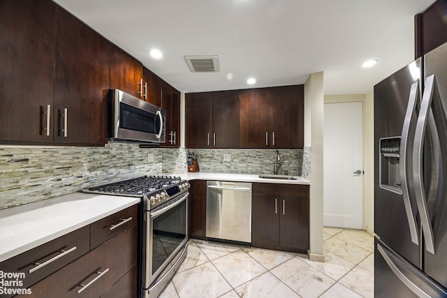 kitchen featuring backsplash, sink, stainless steel appliances, and dark brown cabinets