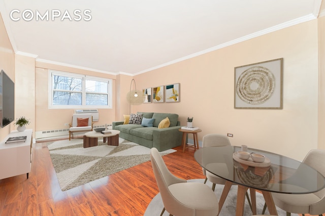 living room featuring baseboard heating, crown molding, and hardwood / wood-style flooring