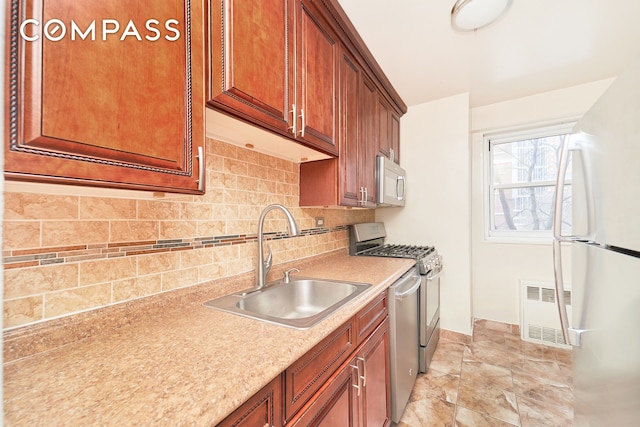 kitchen featuring appliances with stainless steel finishes, tasteful backsplash, and sink