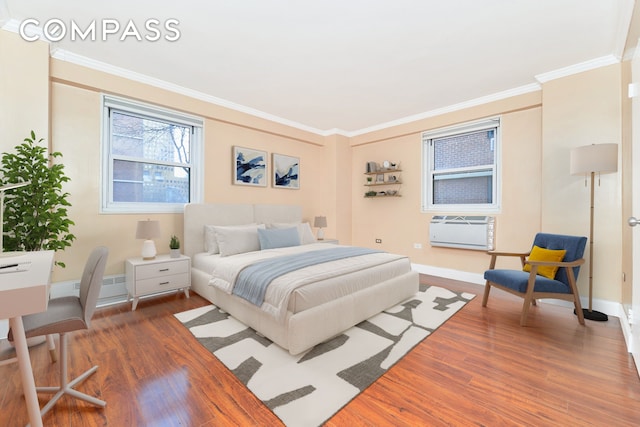 bedroom featuring hardwood / wood-style floors, a wall unit AC, and ornamental molding