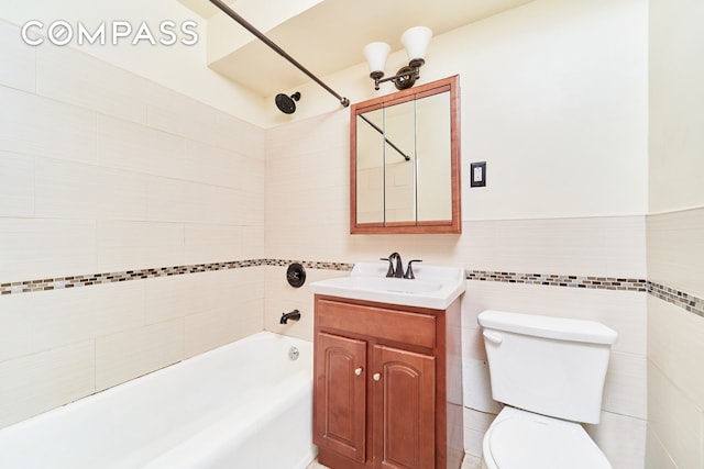 full bathroom featuring vanity, toilet, tiled shower / bath, and tile walls