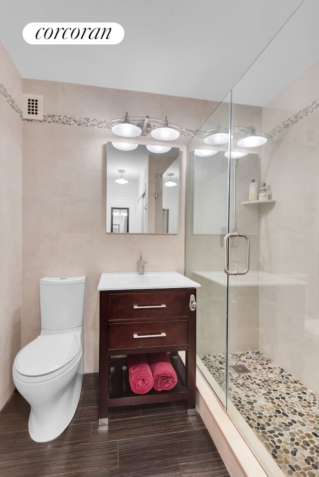 bathroom featuring vanity, toilet, and an enclosed shower