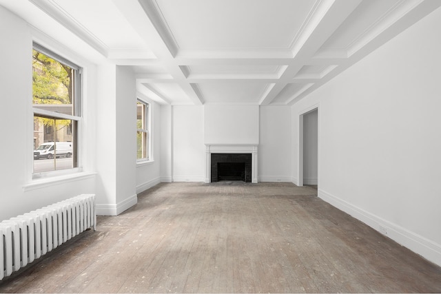 unfurnished living room featuring beam ceiling, radiator heating unit, and coffered ceiling