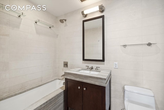 full bathroom with vanity, toilet, tiled shower / bath, and tile walls