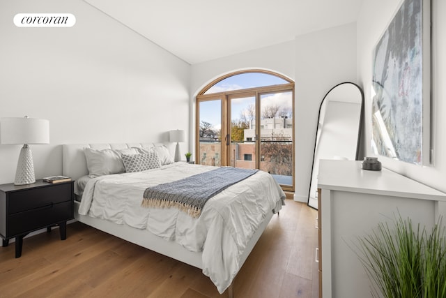 bedroom featuring lofted ceiling and light wood-type flooring