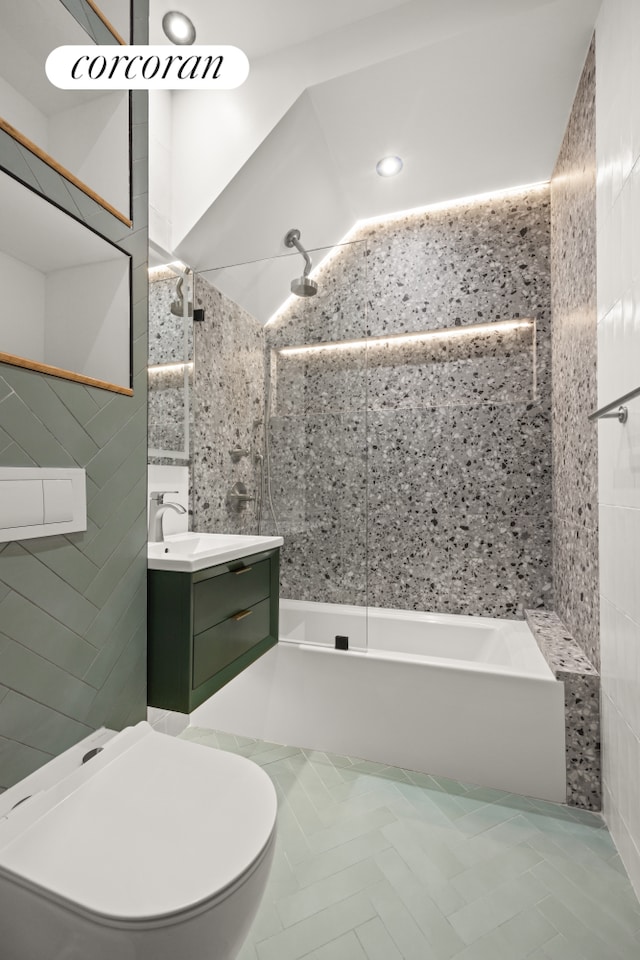 full bathroom featuring vanity, toilet, tile walls, and tiled shower / bath combo