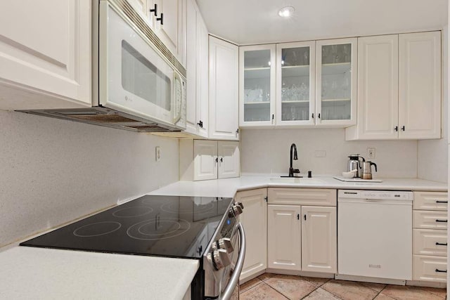 kitchen featuring white cabinetry, white appliances, sink, and light tile patterned floors