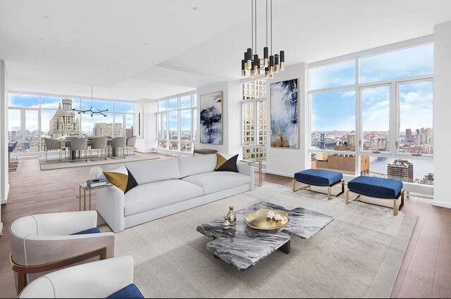 living room with hardwood / wood-style flooring, floor to ceiling windows, and an inviting chandelier