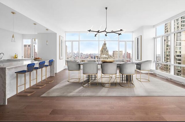 dining room featuring a wealth of natural light, dark hardwood / wood-style flooring, sink, and a notable chandelier