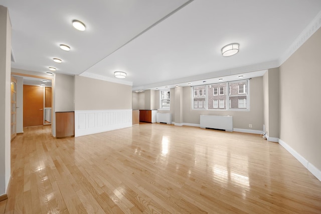 unfurnished room featuring radiator, light hardwood / wood-style flooring, and ornamental molding