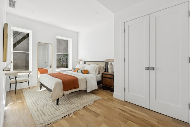 bedroom with multiple windows and light hardwood / wood-style flooring