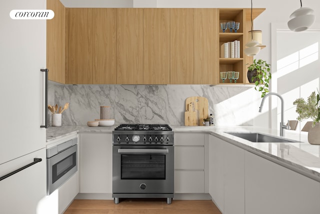 kitchen featuring built in microwave, sink, stainless steel stove, decorative backsplash, and white cabinets