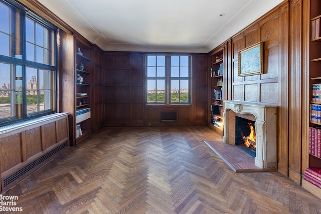 unfurnished office featuring dark parquet flooring, a wealth of natural light, and wooden walls