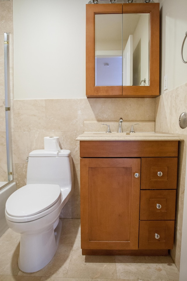 full bathroom featuring vanity, toilet, tile walls, and enclosed tub / shower combo