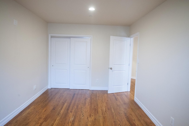 unfurnished bedroom featuring a closet and dark hardwood / wood-style flooring