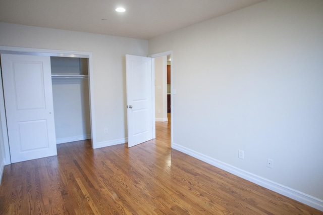 unfurnished bedroom featuring dark hardwood / wood-style floors and a closet