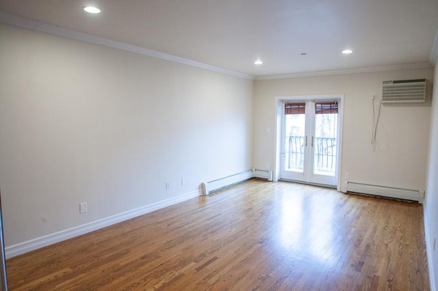 spare room featuring light hardwood / wood-style floors, ornamental molding, and a baseboard heating unit