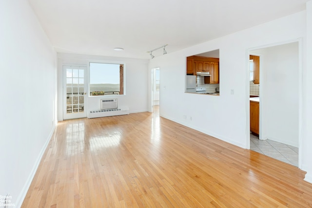 unfurnished living room featuring light hardwood / wood-style floors and track lighting