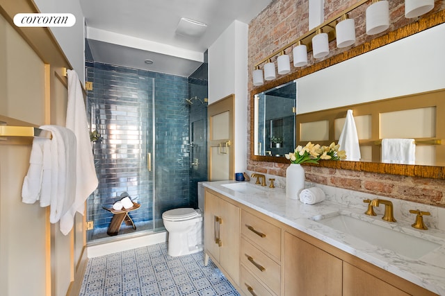 bathroom featuring vanity, toilet, a shower with shower door, and brick wall