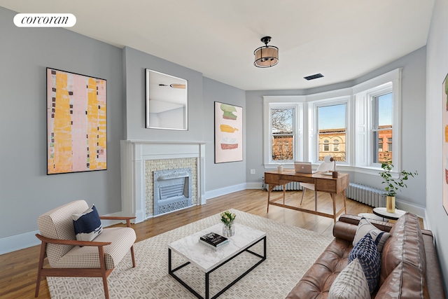 interior space with radiator, a fireplace, and light wood-type flooring