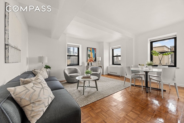 living room with radiator heating unit, plenty of natural light, and parquet floors