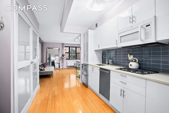 kitchen featuring backsplash, sink, white cabinetry, and stainless steel appliances