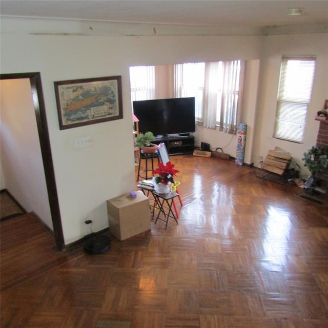 living room featuring plenty of natural light and dark parquet floors