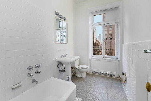 bathroom featuring a bathing tub, sink, tile patterned flooring, toilet, and tile walls