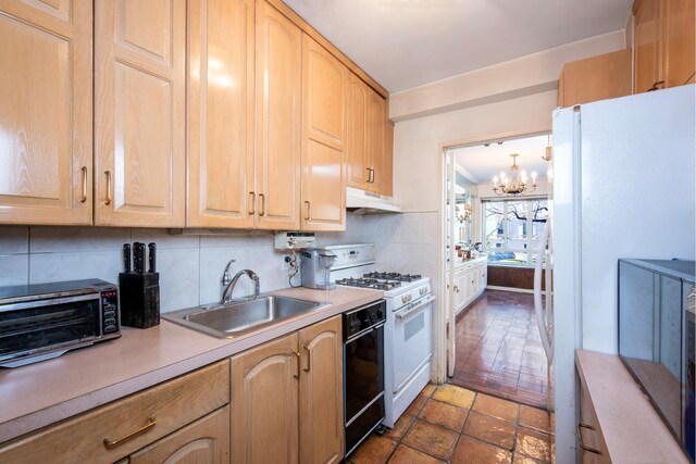 kitchen with light brown cabinetry, backsplash, white appliances, sink, and an inviting chandelier