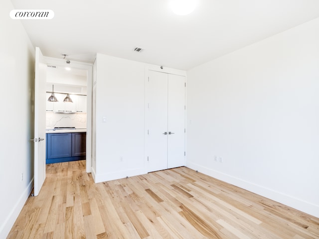 unfurnished bedroom with light hardwood / wood-style floors and a closet