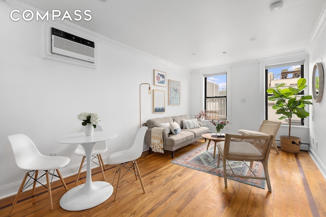 living room with a wall mounted air conditioner, light wood-type flooring, and ornamental molding