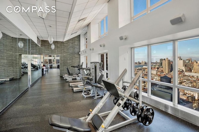 gym featuring a high ceiling and a drop ceiling