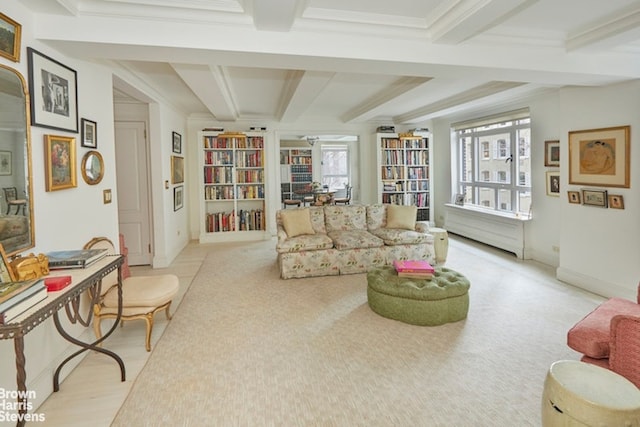 sitting room featuring beam ceiling, ornamental molding, and light carpet