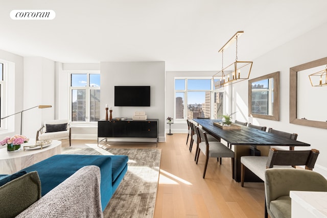 living room featuring light wood-type flooring and an inviting chandelier